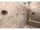 Shower with beige tiling, stone floor, seating, and bronze hardware at 2607 W Gray Wolf Trl, Phoenix, AZ 85085