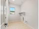 Clean laundry room with window, light wood floors, and convenient hookups at 26914 W Renee Dr, Buckeye, AZ 85396