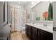 Bathroom featuring double sink vanity, shower with curtain and wood look floors at 27276 N 81St Ln, Peoria, AZ 85383