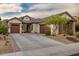 Charming home featuring a three-car garage, stone accents, well-maintained landscaping, and a welcoming front entrance at 27276 N 81St Ln, Peoria, AZ 85383