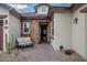 Inviting front entrance featuring a stone facade, outdoor seating, and brick paved patio leading to a modern door at 27276 N 81St Ln, Peoria, AZ 85383