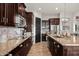 Charming kitchen with stone countertops, stainless appliances, and dark wood cabinetry at 27276 N 81St Ln, Peoria, AZ 85383