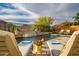 Backyard pool area with waterfall feature, lounge chairs and mountain views at 27276 N 81St Ln, Peoria, AZ 85383