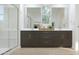 Modern bathroom featuring a double vanity with sleek cabinets, quartz countertop, and a glass-enclosed shower at 3114 S 155Th Ln, Goodyear, AZ 85338