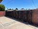 View of the wooden gate, shows privacy and boundary of the backyard, next to a brick wall at 3513 W Maryland Ave, Phoenix, AZ 85019