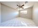 Bright bedroom with a ceiling fan, tiled floor, and natural light from the window at 3513 W Maryland Ave, Phoenix, AZ 85019