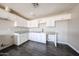 Bright kitchen featuring white cabinets, light countertops, and modern dark laminate wood flooring at 3513 W Maryland Ave, Phoenix, AZ 85019