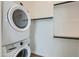 Modern laundry room with stacked washer and dryer, and custom shelving at 3752 E Terrel St, San Tan Valley, AZ 85143