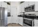 Kitchen with white cabinets, stainless steel appliances, and black countertops at 3806 N 23Rd Ave, Phoenix, AZ 85015