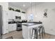 A modern kitchen with white cabinets, dark counters, pendant lights, stainless appliances, and bar stool seating at 3806 N 23Rd Ave, Phoenix, AZ 85015