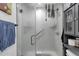 Walk-in shower with clear glass and gray stone tile, plus a storage cabinet at 3806 N 23Rd Ave, Phoenix, AZ 85015