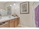 Well-lit bathroom featuring a white countertop, wood cabinets, and a glass-enclosed shower at 40061 W Novak Ln, Maricopa, AZ 85138