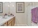 Well-lit bathroom with a white sink, wood cabinets, walk-in shower and decorative artwork at 40061 W Novak Ln, Maricopa, AZ 85138