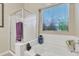Bright bathroom showcasing a tub, a glass-enclosed shower, and a window with blinds at 40061 W Novak Ln, Maricopa, AZ 85138