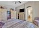 Well lit bedroom with decorative storage cabinets, ceiling fan and ensuite bath at 40061 W Novak Ln, Maricopa, AZ 85138