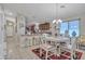 Dining room featuring white chairs, a decorative chandelier, and a glimpse of the kitchen at 40061 W Novak Ln, Maricopa, AZ 85138