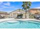 Backyard pool surrounded by patio, lush desert landscaping, and outdoor dining area at 40061 W Novak Ln, Maricopa, AZ 85138