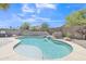 Backyard pool with stone waterfall feature and lush landscaping on a sunny day at 40061 W Novak Ln, Maricopa, AZ 85138