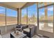Sun room with wicker furniture, large windows, and view of the landscaped backyard with a pool at 40061 W Novak Ln, Maricopa, AZ 85138