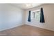 Bright bedroom featuring light colored walls, light colored flooring and a window with blue curtains at 405 E Stanford Ave, Gilbert, AZ 85234
