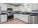Updated kitchen with white cabinets, stainless steel appliances, and light colored flooring at 405 E Stanford Ave, Gilbert, AZ 85234