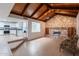 View of living room with stone fireplace, wood paneled vaulted ceiling, and open layout to the kitchen at 405 E Stanford Ave, Gilbert, AZ 85234