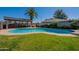 Backyard pool with lush green lawn and covered patio area for outdoor entertaining at 405 E Stanford Ave, Gilbert, AZ 85234