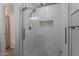 Updated shower features white subway tile, pebble floor and niche, and a clear glass door at 405 E Stanford Ave, Gilbert, AZ 85234