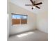 Bright bedroom with a large window offering natural light, a ceiling fan, and neutral-colored carpeting at 4625 E Villa Maria Dr, Phoenix, AZ 85032