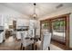 Cozy dining area adjacent to the kitchen with a glass table, stylish chairs, and a view of the backyard pool at 4625 E Villa Maria Dr, Phoenix, AZ 85032