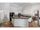 Modern kitchen with white cabinets, dark countertops, and stainless steel appliances, centered around a functional island with sink at 4625 E Villa Maria Dr, Phoenix, AZ 85032