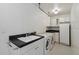 Functional laundry room with modern appliances, black countertops, ample storage, and black and white patterned floors at 4625 E Villa Maria Dr, Phoenix, AZ 85032