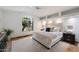 Bright main bedroom featuring a large window, plush carpeting, a decorative headboard, and stylish bedside tables at 4625 E Villa Maria Dr, Phoenix, AZ 85032