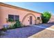 View of charming single-story home with a gravel yard and arched entryway at 4625 W Thomas Rd # 71, Phoenix, AZ 85031