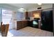 Charming kitchen featuring tile floors, brown cabinets, and black appliances at 4625 W Thomas Rd # 71, Phoenix, AZ 85031