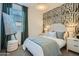 Stylish bedroom with a neutral color palette, patterned accent wall, and ample natural light at 4698 E French Rd, San Tan Valley, AZ 85143