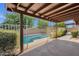 Back patio showing a pool with a safety fence and lush greenery at 4913 E Acoma Dr, Scottsdale, AZ 85254