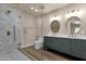 Luxurious bathroom featuring a glass-enclosed shower and a double vanity with stylish mirrors at 4913 E Acoma Dr, Scottsdale, AZ 85254