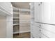 Walk-in closet featuring adjustable shelving and ample storage space with white cabinets and drawers at 4913 E Acoma Dr, Scottsdale, AZ 85254