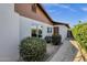 A charming home exterior with lush green bushes, neutral paint, and a light-colored walkway at 4913 E Acoma Dr, Scottsdale, AZ 85254