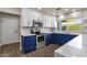 Stylish kitchen with white and blue cabinets, stainless steel appliances, and bright countertops at 4913 E Acoma Dr, Scottsdale, AZ 85254