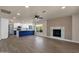 Modern eat-in kitchen and living room features white cabinets, wood floors and fireplace at 4913 E Acoma Dr, Scottsdale, AZ 85254