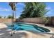 Inviting backyard pool featuring cool blue water, a tanning ledge, and palm trees at 4913 E Acoma Dr, Scottsdale, AZ 85254