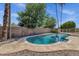 Refreshing backyard pool surrounded by lush landscaping, mature shade trees, and a pebble surface at 4913 E Acoma Dr, Scottsdale, AZ 85254