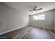 This bedroom features wood-look floors, a ceiling fan, and a window for natural light at 5336 W Lewis Ave, Phoenix, AZ 85035