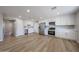 Open kitchen features white cabinets, stainless appliances, and wood look flooring at 5336 W Lewis Ave, Phoenix, AZ 85035