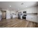 Spacious kitchen with stainless steel appliances, white cabinets, and wood flooring at 5336 W Lewis Ave, Phoenix, AZ 85035