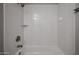 A tiled shower and tub, featuring new fixtures and shelving at 5336 W Lewis Ave, Phoenix, AZ 85035