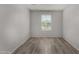 Serene bedroom with wood-look tile flooring, a large window, and neutral walls at 5621 S 30Th Gln, Phoenix, AZ 85041