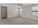 Light-filled primary bedroom with neutral carpet, ceiling fan, and two windows at 5621 S 30Th Gln, Phoenix, AZ 85041